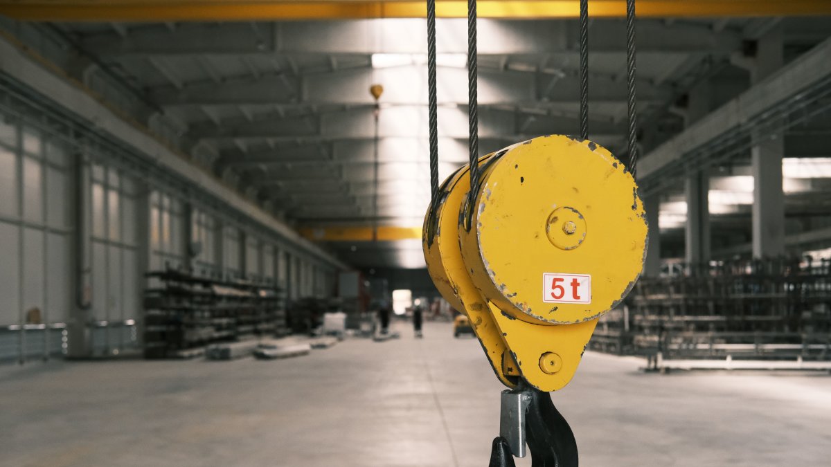 Closeup of a 5-ton yellow crane hook in an empty warehouse